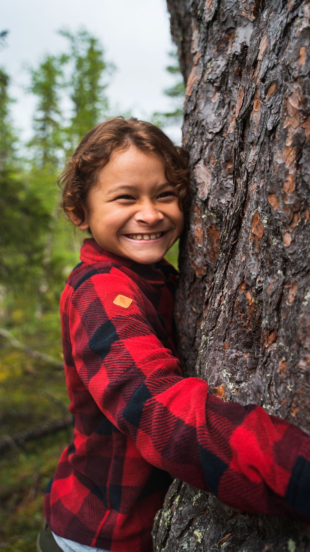 En flicka utforskar träd i naturen med Pinewood